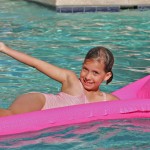 Little girl on raft in swimming pool