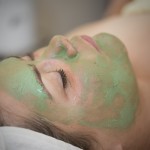 A young girl getting a facial mask at a spa r
